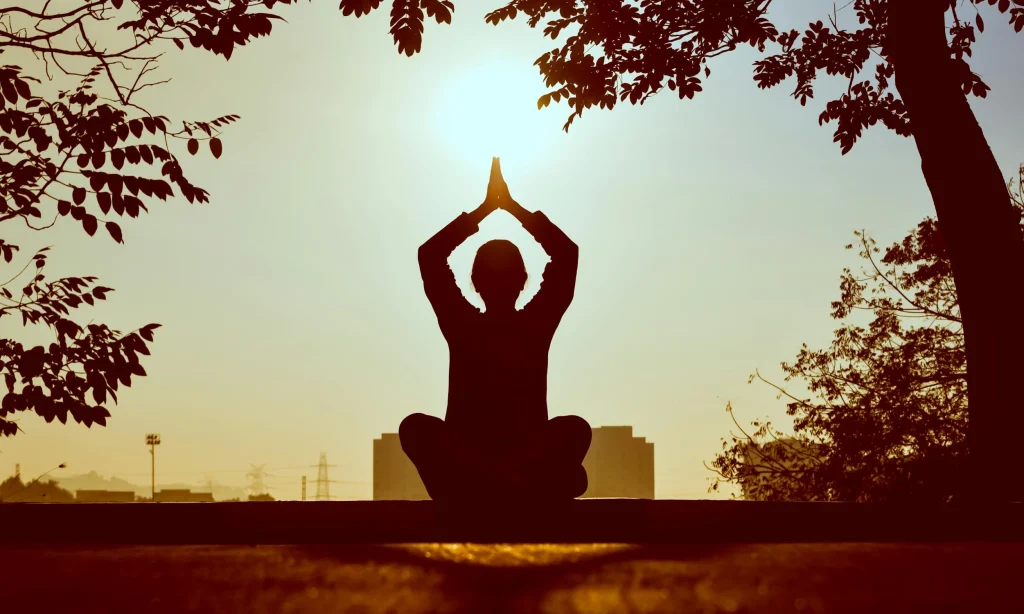 Woman doing yoga pose during sunset.